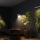 Alt text: Sala moderna com iluminação fotossintética para plantas indoor, incluindo Monstera, Ficus lyrata e jardim vertical iluminados por luminárias LED para cultivo e paisagismo interno.