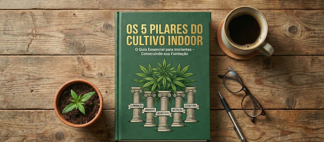 Livro “Os 5 Pilares do Cultivo Indoor” sobre mesa de madeira com muda em vaso, café, óculos e caneta, representando guia essencial para iniciantes no cultivo indoor.